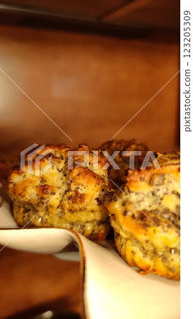 Poppy seed savory muffins resting on white porcelain, showcasing golden brown crust and flaky texture, ideal for brunch gathering copy space Poppy seed savory muffins resting on white porcelain, showcasing golden brown crust and flaky texture, ideal for brunch gathering copy space 123205309
