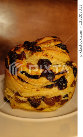 Easter sweet bread adorned with raisins, dried fruits, resting appetizingly on pristine white plate, celebrating holiday culinary tradition copy space Easter sweet bread adorned with raisins, dried fruits, resting appetizingly on pristine white plate, celebrating holiday culinary tradition copy space 123205313