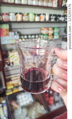 Woman holding a glass of karkade Hibiscus tea in marsa alam herbal shop, egypt 123205376