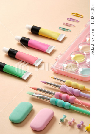 Stationery and supplies for drawing and crafts. Watercolor, gouache, acrylic paints, brushes, pencils on beige background Stationery and supplies for drawing and crafts. Watercolor, gouache, acrylic paints, brushes, pencils on beige background 123205393