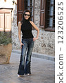 Attractive woman age model 51 years old posing in fashionable jeans with beads in the Old Town in Antalya Turkey 123206525