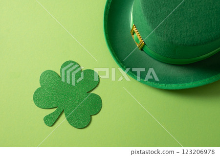 St Patricks day and March 17 concept with green Leprechaun Hat and clover leaf on green background. Close up. View from above. St Patricks day and March 17 concept with green Leprechaun Hat and clover leaf on green background. Close up. View from above. 123206978
