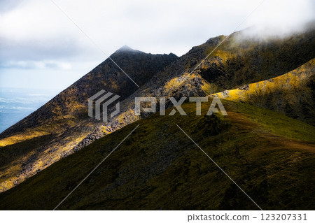 the Carrauntoohil walkway, Ireland's highest peak, surrounded by dramatic landscapes and rolling hills under a moody sky. the Carrauntoohil walkway, Ireland's highest peak, surrounded by dramatic landscapes and rolling hills under a moody sky. 123207331