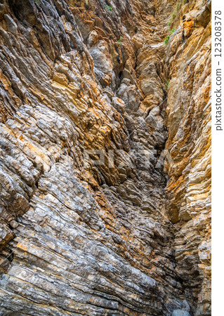 Layered rock texture in Budva, Montenegro. Sedimentary rocks with rugged surface of gray and brown. Natural formation of layers and cracks, geological structure. Layered rock texture in Budva, Montenegro. Sedimentary rocks with rugged surface of gray and brown. Natural formation of layers and cracks, geological structure. 123208378