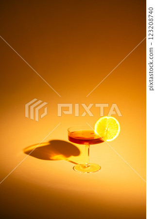 glass of champagne with a slice of orange on an orange background, with hard light glass of champagne with a slice of orange on an orange background, with hard light 123208740