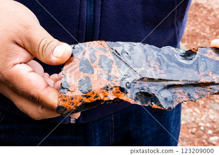 Tourist guide showing an obsidian piece to a group of visitors at the Teotihuacan archeological site. 123209000