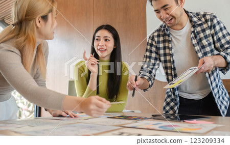 Diverse design team sharing ideas and collaborating on project at office table. Diverse design team sharing ideas and collaborating on project at office table. 123209334