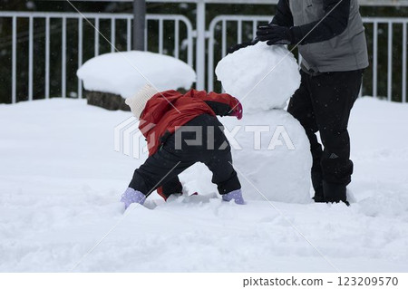 Parents and children making a snowman Parents and children making a snowman 123209570