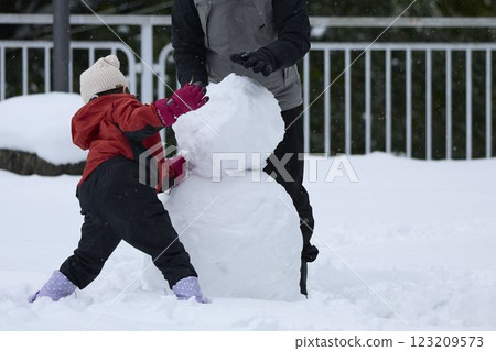 Parents and children making a snowman 123209573