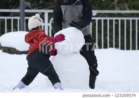 Parents and children making a snowman Parents and children making a snowman 123209574