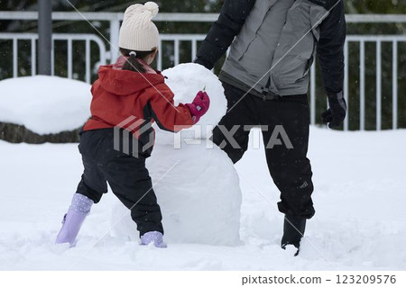 Parents and children making a snowman 123209576