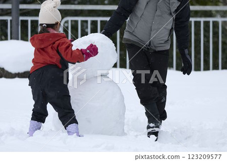 Parents and children making a snowman 123209577