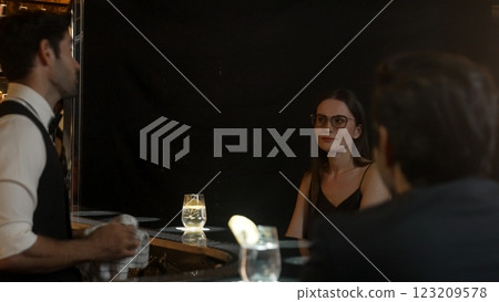 Woman and friends special in drink gin fizz with barman wiping glass. Vinosity. 123209578