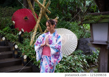 Woman in Kimono Meditating Near Japanese Umbrellas  123209638