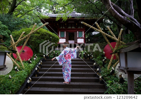 Woman in Kimono Gracefully Posing on Temple Steps  123209642
