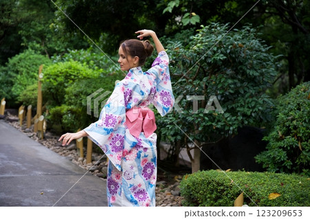 Elegant Woman in Kimono Striking a Graceful Pose Outdoors  123209653