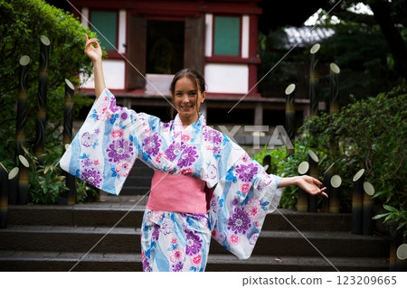 Smiling Woman in Floral Kimono Posing Near Japanese Temple Smiling Woman in Floral Kimono Posing Near Japanese Temple 123209665