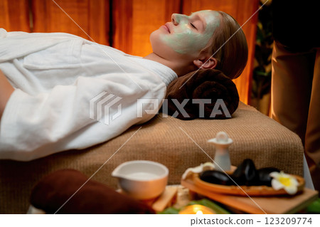 Woman indulges in rejuvenating with luxurious face cream spa massage. Quiescent Woman indulges in rejuvenating with luxurious face cream spa massage. Quiescent 123209774
