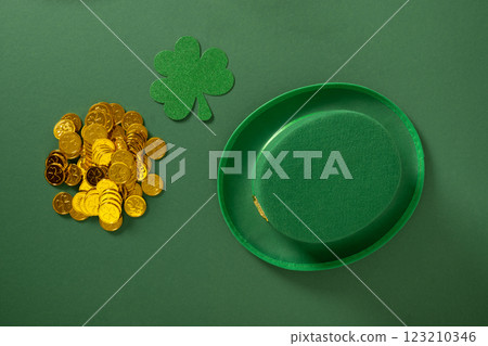 St Patricks day and March 17 concept with golden coins, clover leaves, green Leprechaun Hat with belt and buckle on green background. Close up. St Patricks day and March 17 concept with golden coins, clover leaves, green Leprechaun Hat with belt and buckle on green background. Close up. 123210346