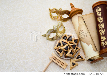 Purim Celebrations. Golden mask, scroll, gragger, and hamantaschen on decorative background Purim Celebrations. Golden mask, scroll, gragger, and hamantaschen on decorative background 123210726