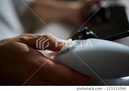 A closeup photo of a hand firmly gripping a gaming controller, ready for action in gameplay 123211098