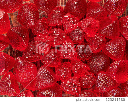 Candies in the shape of strawberries and raspberries in close-up. Wooden brown background. Candies in the shape of strawberries and raspberries in close-up. Wooden brown background. 123211580