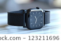 Black Apple Watch with matching band rests on table 123211696