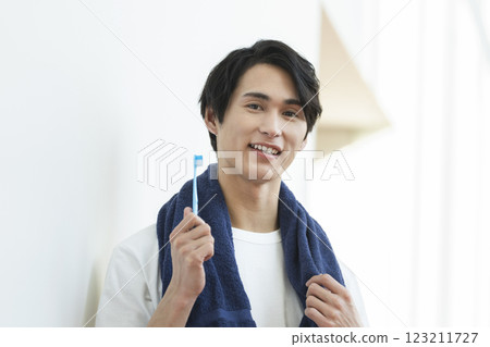 A man in his late 20s holding a toothbrush A man in his late 20s holding a toothbrush 123211727