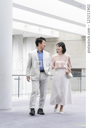 一對 50 多歲的夫婦微笑著散步 一對 50 多歲的夫婦微笑著散步 123211902
