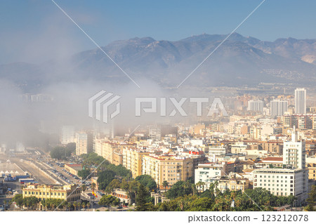 Malaga, seaside city in Andalusia, Spain, Europe. Coastal city shrouded in morning mist, mountains in the background. Malaga, seaside city in Andalusia, Spain, Europe. Coastal city shrouded in morning mist, mountains in the background. 123212078