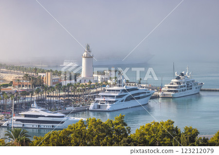 Malaga, seaside city in Andalusia, Spain, Europe. Luxury yachts docked at a harbor with a lighthouse and a cruise ship in the distance. 123212079