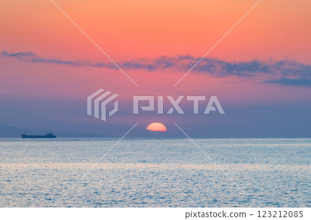 Sunrise view from Malaga seaside city in Andalusia, Spain, Europe. Serene sunrise over calm ocean waters, a lone vessel on the horizon. Sunrise view from Malaga seaside city in Andalusia, Spain, Europe. Serene sunrise over calm ocean waters, a lone vessel on the horizon. 123212085