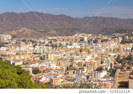 Malaga, seaside city in Andalusia, Spain, Europe. Cityscape panorama with mountains in the background. A sprawling urban view from an elevated vantage point. 123212114