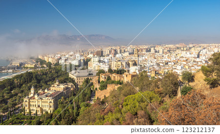 Malaga, seaside city in Andalusia, Spain, Europe. Panoramic view of a city nestled amongst hills and mountains under a clear blue sky. 123212137