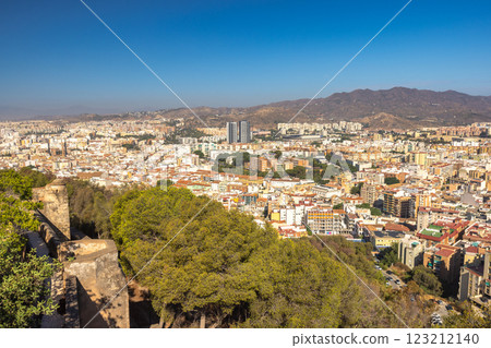 Malaga, seaside city in Andalusia, Spain, Europe. Panoramic view of a city nestled in a valley, surrounded by mountains under a clear blue sky. 123212140