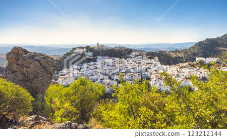Casares town in Andalusia, Spain, Europe. Whitewashed village nestled in a hillside, overlooking a vast valley under a clear blue sky. 123212144