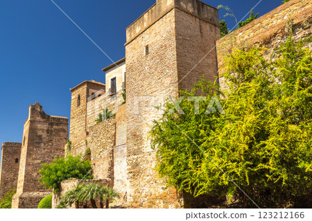 Alcazaba, palace and fortification in Malaga city at Andalusia, Spain, Europe. Ancient stone walls and towers bask in the sun, lush greenery adding a vibrant contrast. 123212166
