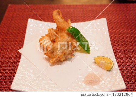 A square white plate with fried Awaji three-year-old tiger pufferfish 123212904