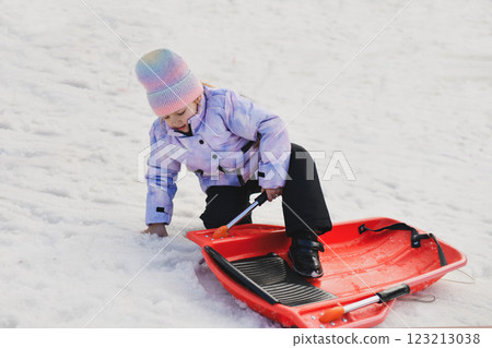 A girl with red snow bob sledding in the snow 123213038