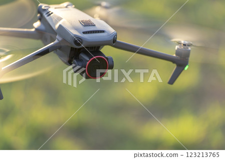 Drone with digital camera and fast rotating propellers flying taking video and pictures Drone with digital camera and fast rotating propellers flying taking video and pictures 123213765