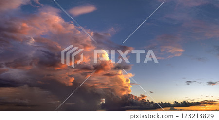 Colorful sunset sky with setting sun behind vivid orange and yellow clouds Colorful sunset sky with setting sun behind vivid orange and yellow clouds 123213829