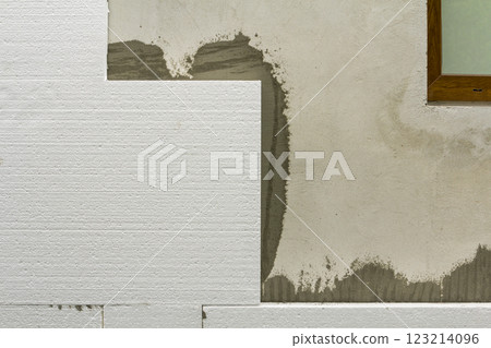Close-up detail of plastered house wall with rigid styrofoam insulation. Modern technology, construction, renovation, energy saving, alternative for mineral wool, warm comfortable house concept. 123214096