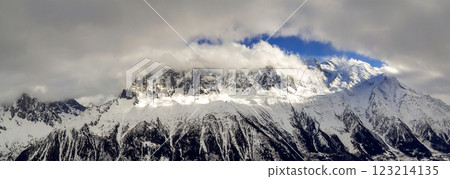 Breathtaking aerial view of Mont Blanc mountain peak covered with shiny snow, ice and glaciers under blue sky with puffy white clouds on the French side of Alps on a clear cold sunny winter day 123214135