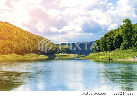 Beautiful landscape with blue water in a river and green trees in forest on mountain hills 123214185
