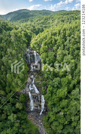 Beautiful landscape of high waterfall with falling down clear water from rocky boulders between green lush woods. Whitewater Falls in Nantahala National Forest, North Carolina, USA 123214186
