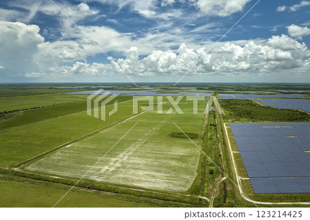 Aerial view of sustainable electrical power plant between agricultural farmlands with photovoltaic panels for producing clean electric energy. Concept of renewable electricity with zero emission 123214425
