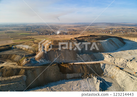 Aerial view of open pit mining site of limestone materials for construction industry with excavators and dump trucks Aerial view of open pit mining site of limestone materials for construction industry with excavators and dump trucks 123214443