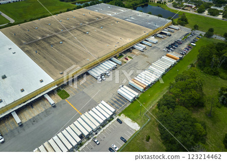 Aerial view of large commercial loading bay with many delivery trucks unloading and uploading retail goods for nationwide distribution. Global economy concept 123214462