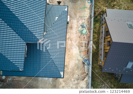 Aerial view of house roof top covered with ceramic shingles. Tiled covering of building under construction 123214469