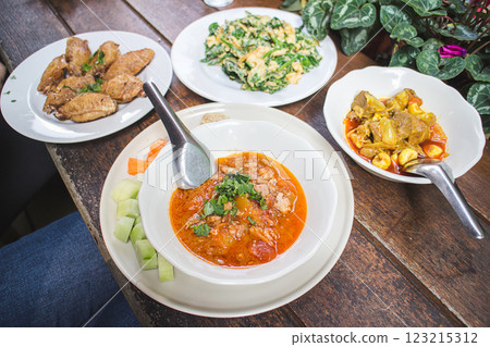 Spicy meat, tomato dip Nam Prik Aong, Hang-le curry pork curry Stir Fried Chiang Da and Chicken wing with fish sauce on white plate on wooden table, Northen Thai food 123215312